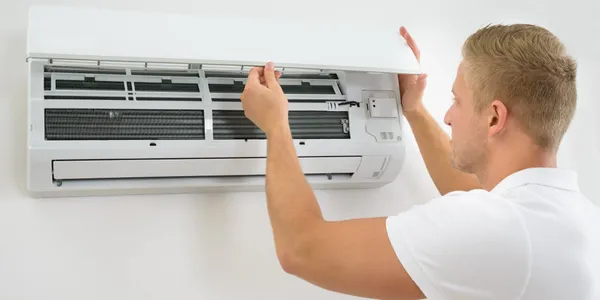 Man fixing a wall-mounted air conditioner